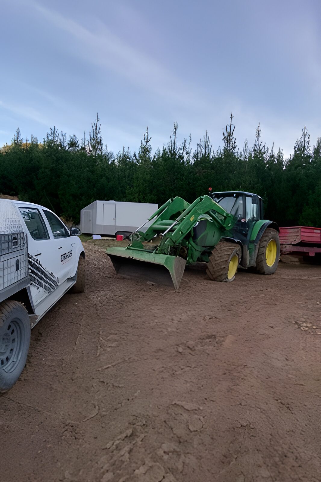 Davo's ute alongside a John Deere loader tractor on a wet paddock call-out